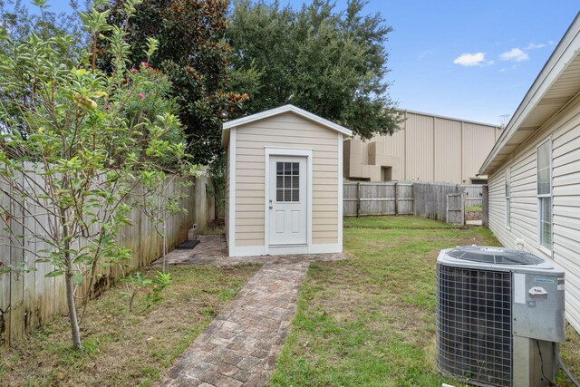 view of outdoor structure with central AC and a lawn