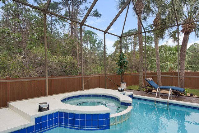 view of pool with glass enclosure and an in ground hot tub