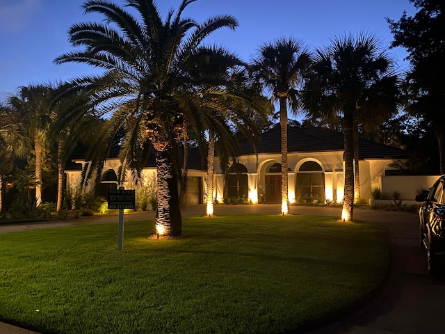 mediterranean / spanish home featuring a front yard