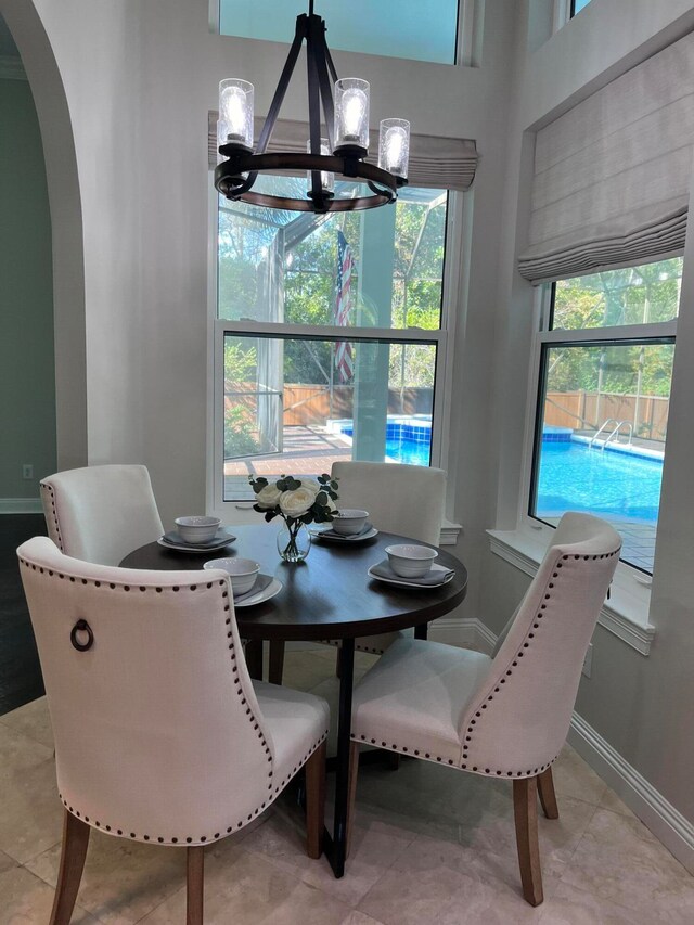 dining room with a wealth of natural light, light tile patterned flooring, and a chandelier