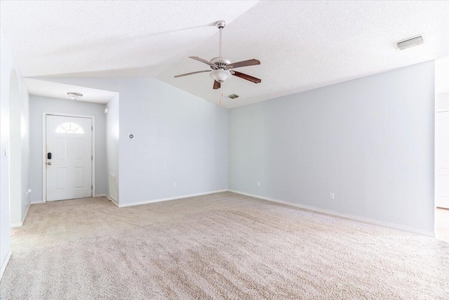 unfurnished room featuring ceiling fan, light colored carpet, a textured ceiling, and vaulted ceiling