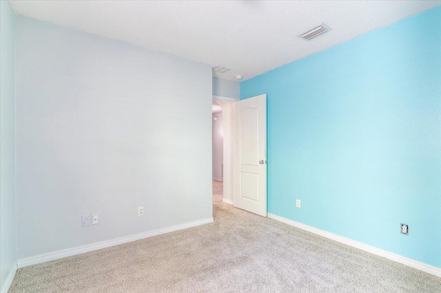 carpeted empty room with a textured ceiling