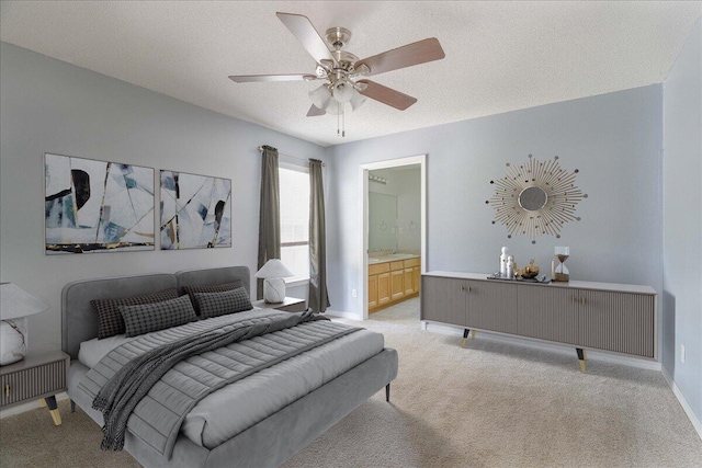 bedroom featuring connected bathroom, ceiling fan, light colored carpet, and a textured ceiling