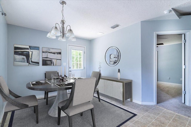 dining area featuring a textured ceiling and a notable chandelier