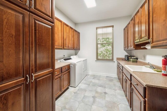 washroom with sink, washing machine and clothes dryer, and cabinets