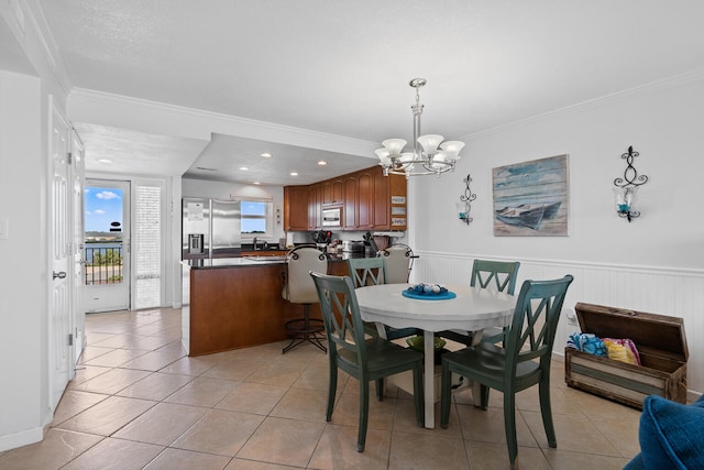 dining area with light tile patterned floors, a chandelier, and ornamental molding