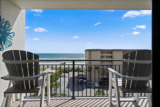 balcony featuring a view of the beach and a water view