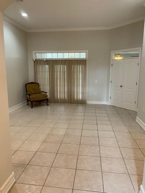 unfurnished room featuring crown molding and light tile patterned floors