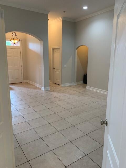 tiled empty room featuring ornamental molding