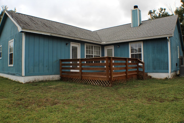 rear view of property with a yard and a wooden deck