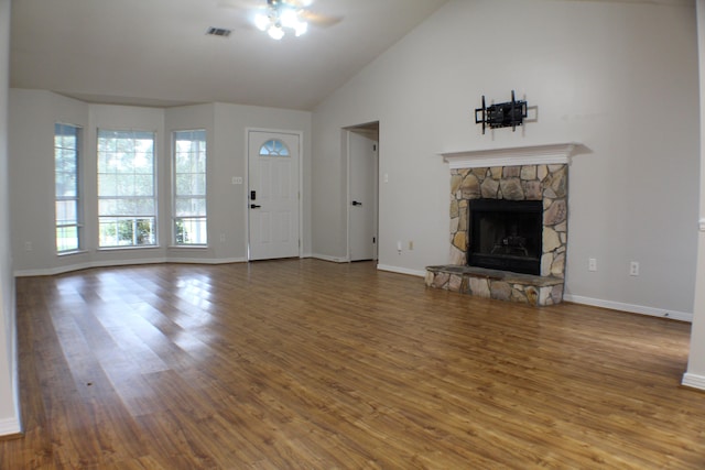 unfurnished living room with ceiling fan, a fireplace, vaulted ceiling, and hardwood / wood-style flooring