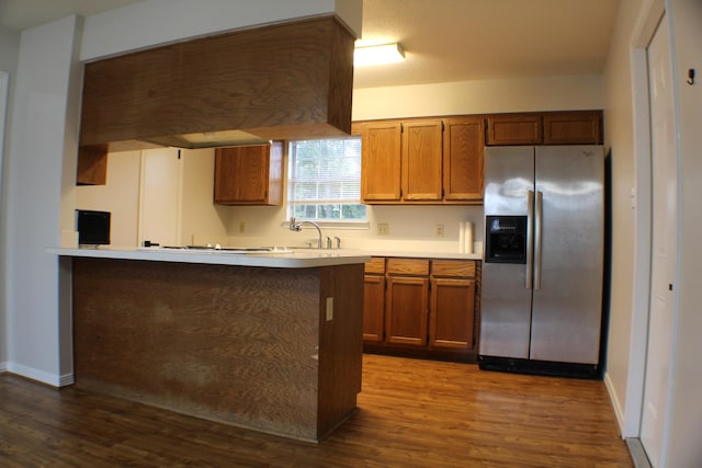 kitchen featuring custom exhaust hood, dark wood-type flooring, sink, stainless steel fridge, and kitchen peninsula