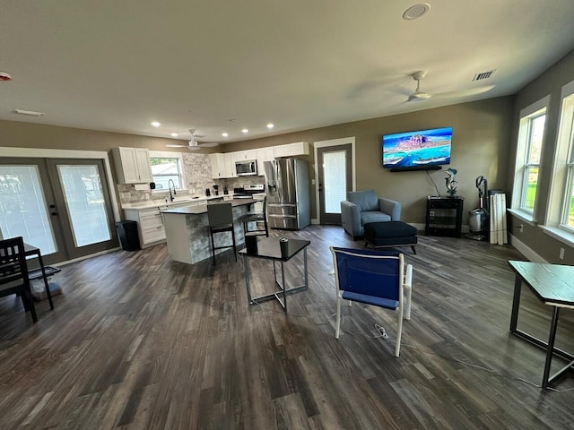 living room with ceiling fan, sink, and dark hardwood / wood-style flooring