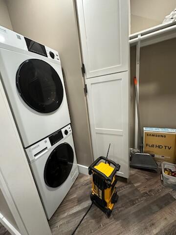 washroom featuring dark hardwood / wood-style flooring and stacked washer and clothes dryer