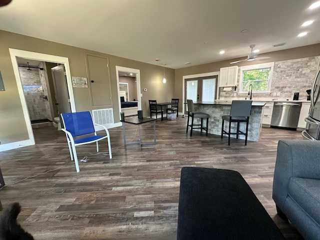 living room featuring ceiling fan and dark hardwood / wood-style flooring