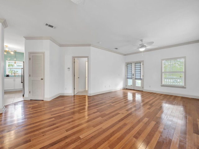 spare room featuring ceiling fan with notable chandelier, crown molding, sink, and light hardwood / wood-style flooring