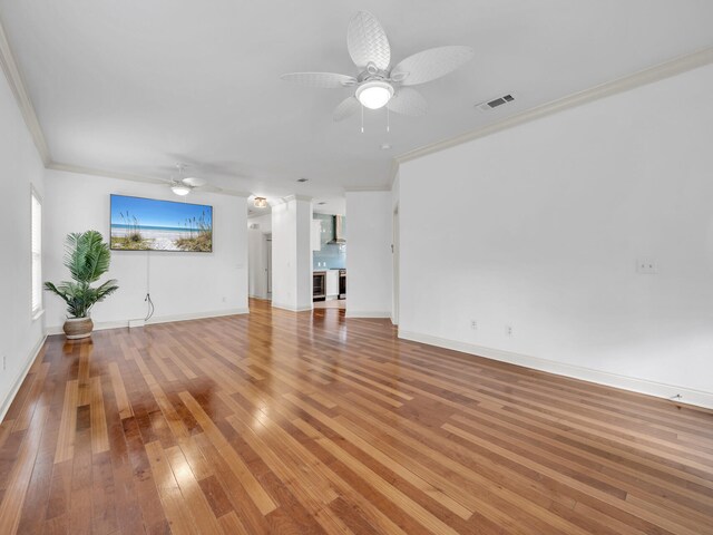 unfurnished living room with wood-type flooring, ceiling fan, and crown molding