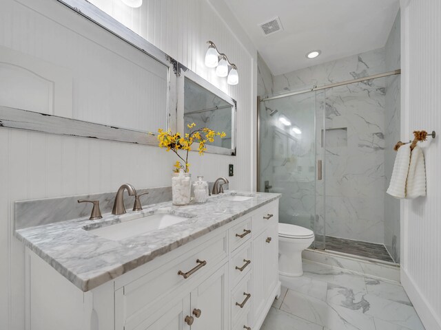 bathroom featuring a shower with door, vanity, and toilet