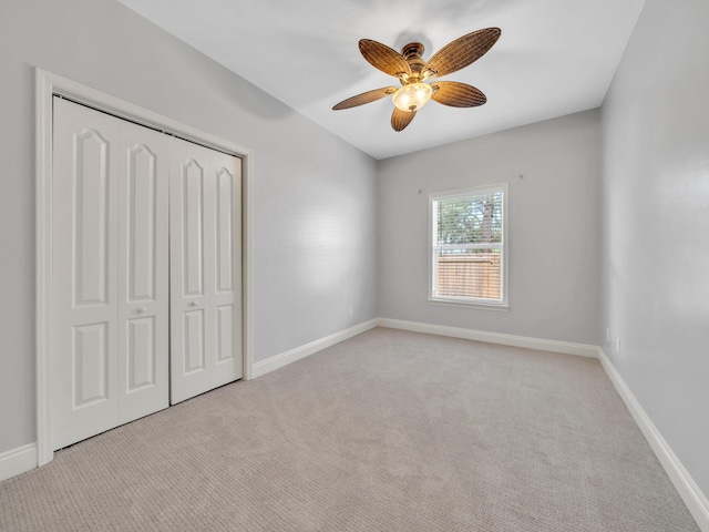 unfurnished bedroom with light carpet, a closet, and ceiling fan