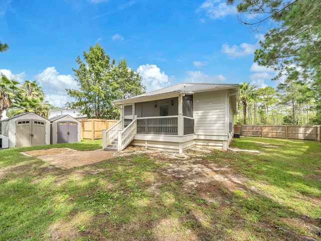 rear view of property featuring a storage shed and a yard