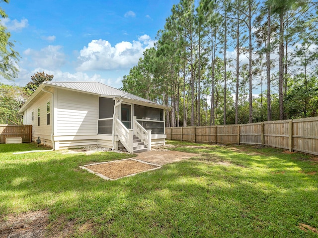 rear view of house featuring a lawn and a sunroom