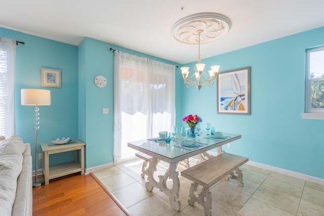 dining area with light hardwood / wood-style flooring and a notable chandelier