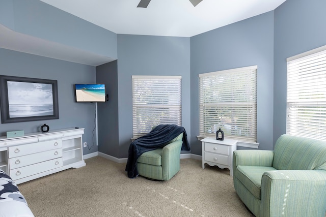 interior space featuring multiple windows, light colored carpet, and ceiling fan