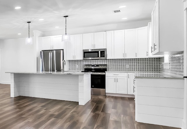 kitchen with a kitchen island, white cabinetry, appliances with stainless steel finishes, and hanging light fixtures