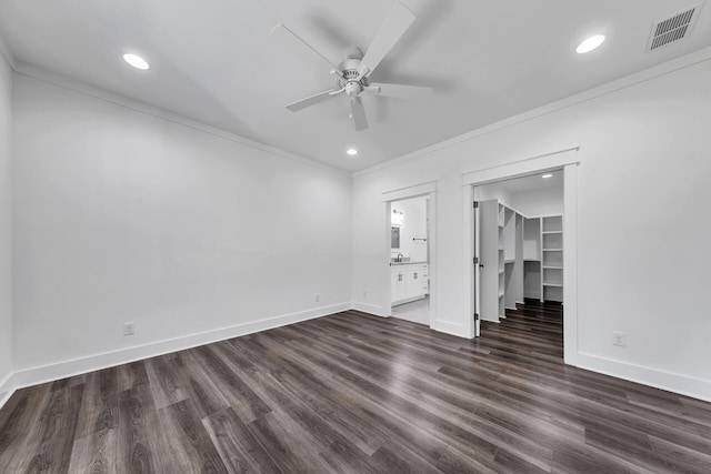 empty room with dark wood-type flooring, ceiling fan, ornamental molding, and sink