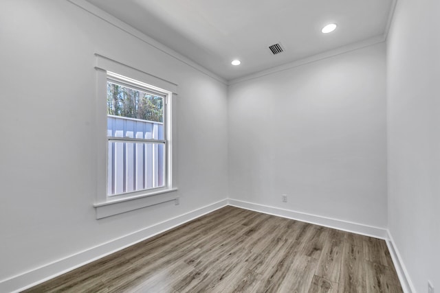 spare room with crown molding and wood-type flooring