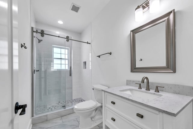 bathroom with a shower with door, vanity, and toilet