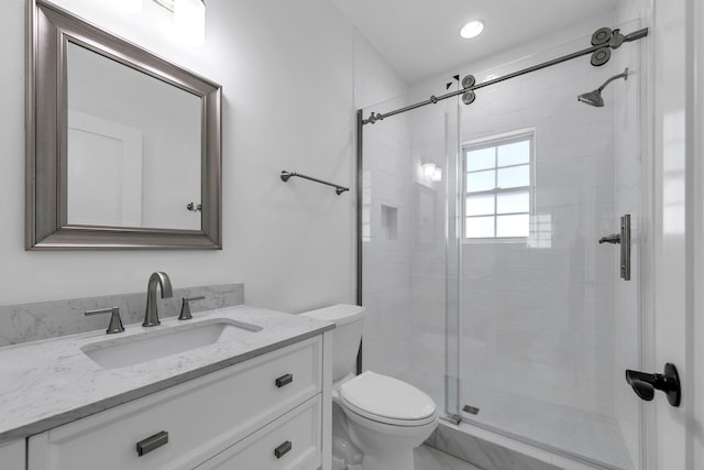 bathroom with vanity, an enclosed shower, and toilet