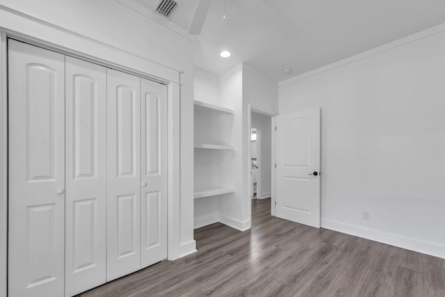 unfurnished bedroom featuring wood-type flooring, a closet, and ceiling fan