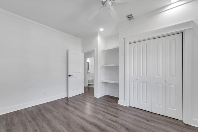 unfurnished bedroom featuring hardwood / wood-style floors, ornamental molding, a closet, and ceiling fan