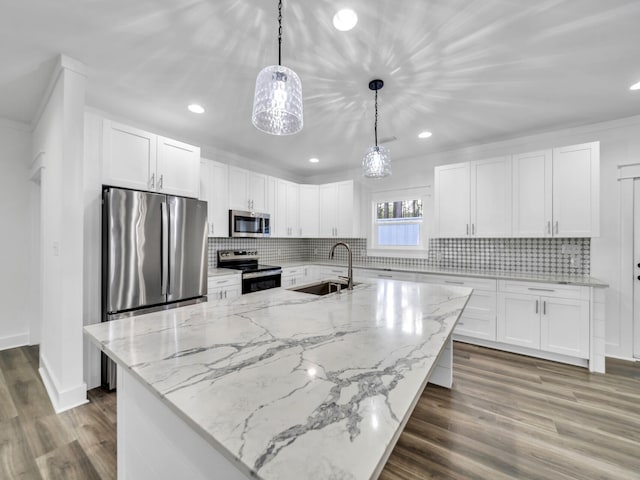 kitchen with stainless steel appliances, white cabinetry, hanging light fixtures, and sink