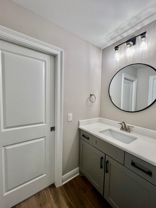 bathroom featuring vanity, wood-type flooring, and a textured ceiling