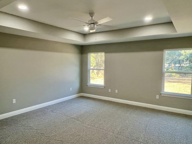 unfurnished room featuring carpet, ceiling fan, and a tray ceiling