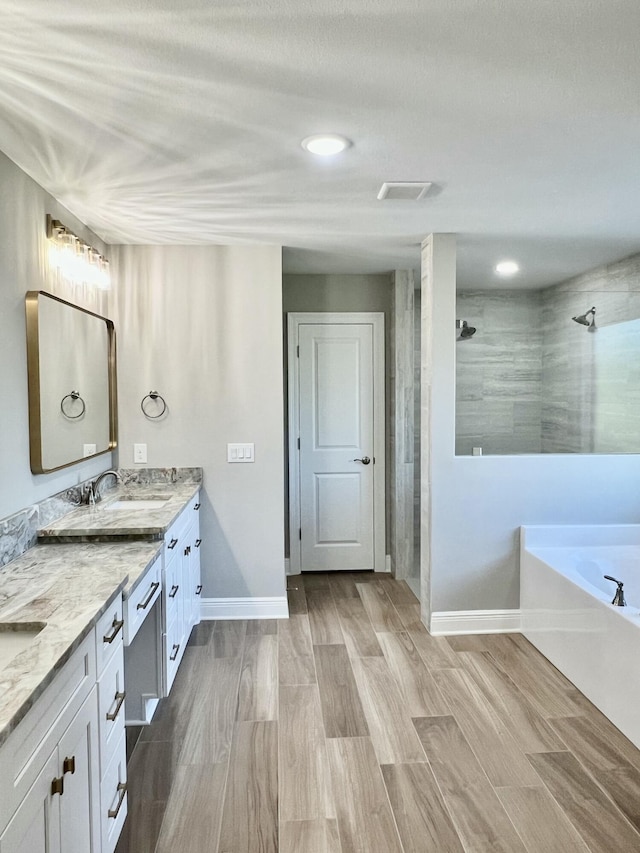 bathroom with independent shower and bath, vanity, and wood-type flooring