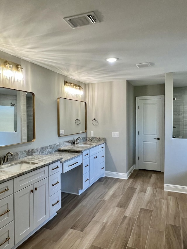 bathroom with vanity, wood-type flooring, and a shower