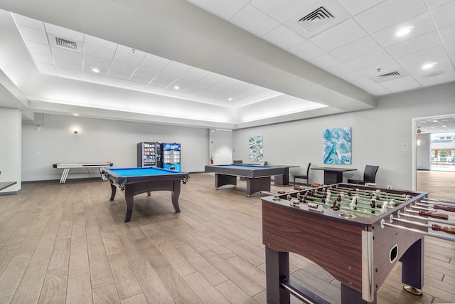 playroom featuring pool table, a drop ceiling, light hardwood / wood-style floors, and a tray ceiling