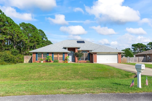 view of front of property with a front yard, solar panels, and a garage