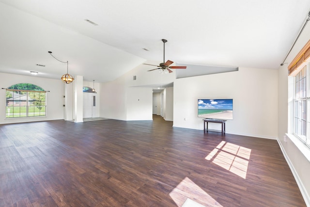 unfurnished living room featuring ceiling fan with notable chandelier, high vaulted ceiling, and dark wood-type flooring