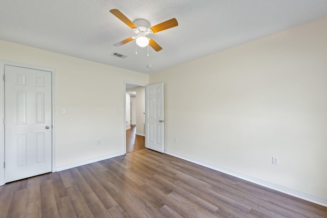 unfurnished bedroom with ceiling fan, a textured ceiling, and hardwood / wood-style flooring