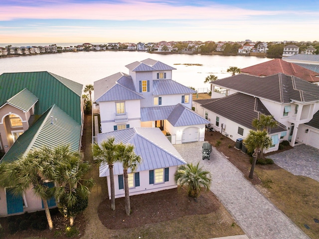 aerial view at dusk featuring a water view