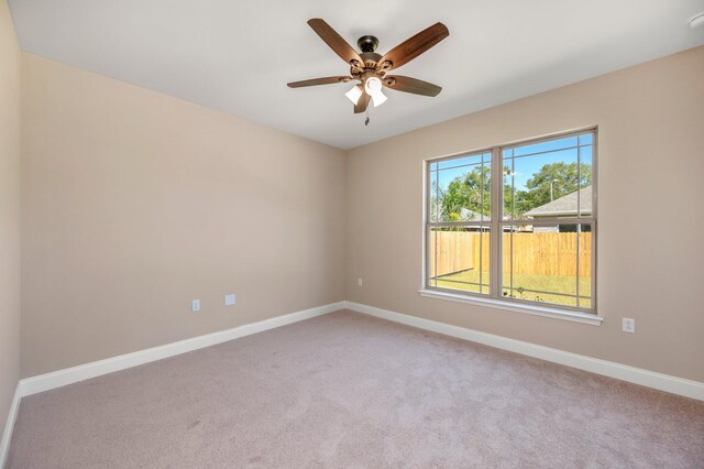 spare room featuring ceiling fan and light carpet