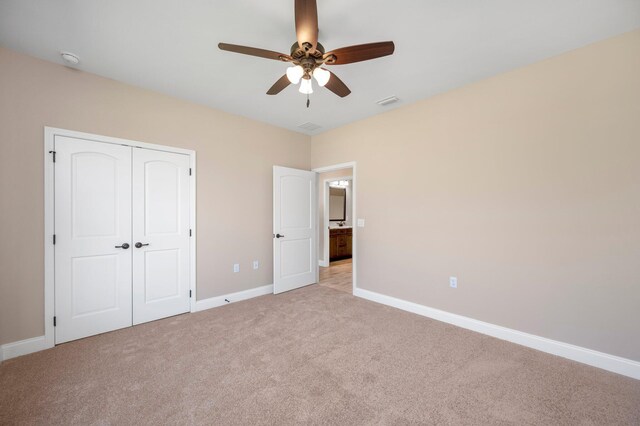 unfurnished bedroom with a closet, ceiling fan, and light carpet