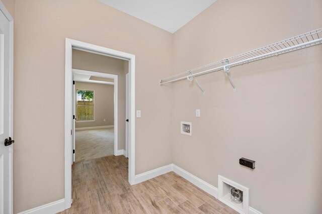 laundry area with washer hookup, electric dryer hookup, and light hardwood / wood-style floors