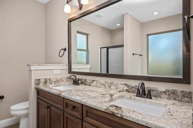 bathroom with vanity, toilet, and an enclosed shower