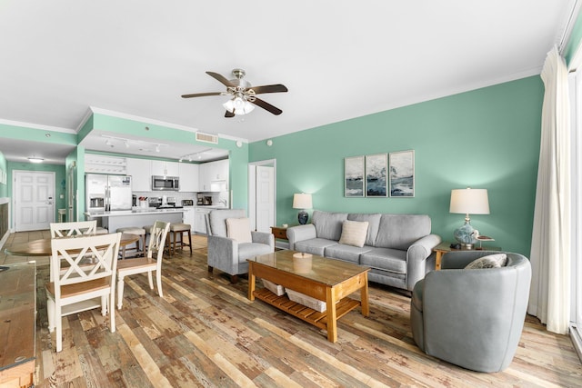 living room with ceiling fan, ornamental molding, and light hardwood / wood-style flooring