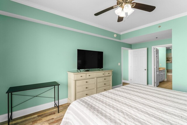 bedroom with ceiling fan, light hardwood / wood-style floors, crown molding, and ensuite bath